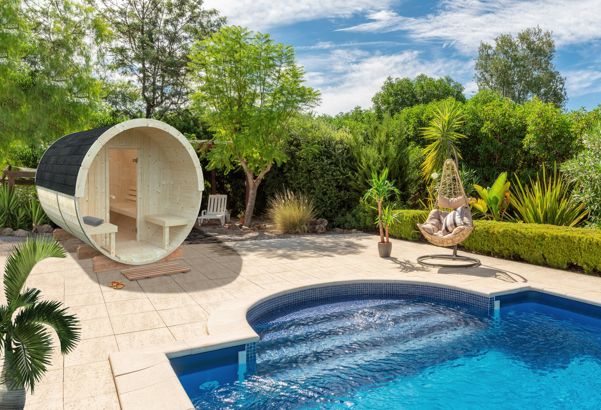 Luxurious pool in the garden of a private villa, hanging chair with pillows for leisure tourists, in summer. Portugal, Algarve.